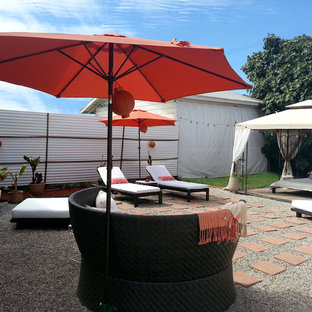 Esempio di un grande patio o portico tropicale dietro casa con ghiaia