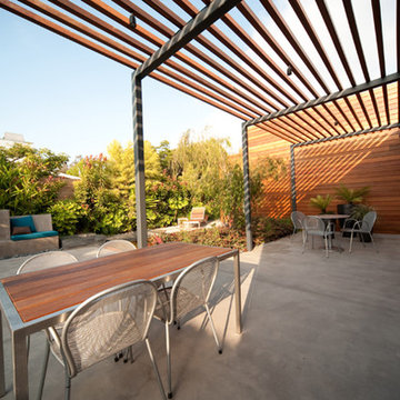 Overhead wood and steel trellis create filtered shade.