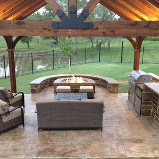 Immagine di un patio o portico american style dietro casa e di medie dimensioni con cemento stampato e un gazebo o capanno