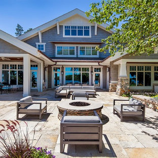 Immagine di un grande patio o portico stile americano dietro casa con un focolare