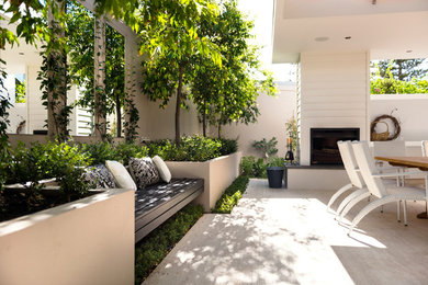 Cette photo montre une terrasse tendance avec un foyer extérieur.