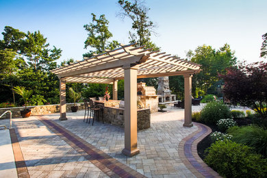 Imagen de patio clásico grande sin cubierta en patio trasero con brasero y adoquines de piedra natural