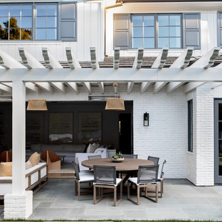 Idee per un grande patio o portico moderno dietro casa con pavimentazioni in cemento e una pergola