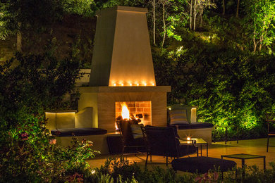Example of a mid-sized classic backyard stone patio design in Los Angeles with a fire pit and no cover