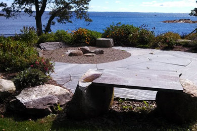 Inspiration for a large timeless backyard stone patio remodel in Portland Maine with a fire pit