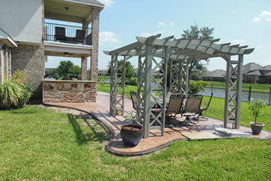 Example of a backyard concrete patio design in Houston with a pergola