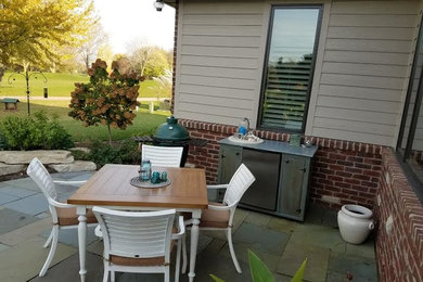 Mid-sized elegant backyard stone patio kitchen photo in Chicago