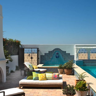 Esempio di un patio o portico mediterraneo con un focolare