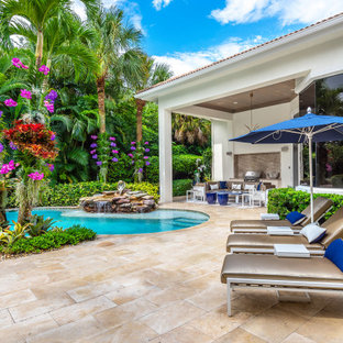 Esempio di un grande patio o portico chic dietro casa con fontane, pavimentazioni in pietra naturale e un tetto a sbalzo
