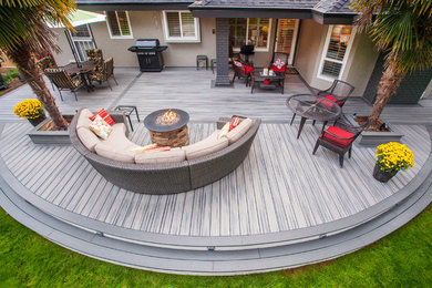 Patio - huge modern backyard patio idea in Vancouver with a fire pit, no cover and decking