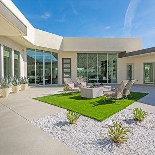 Idee per un patio o portico minimalista con un focolare, lastre di cemento e nessuna copertura