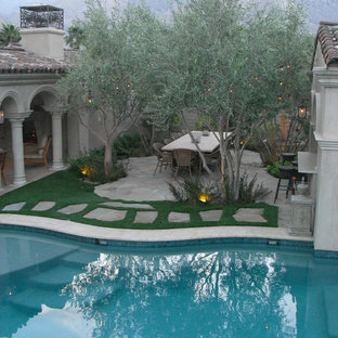 Foto di un ampio patio o portico mediterraneo in cortile con un focolare e una pergola