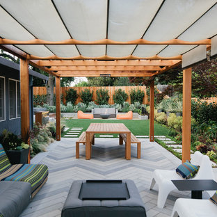 Modelo de patio contemporáneo, de tamaño medio, en patio trasero, con adoquines de hormigón y pérgola