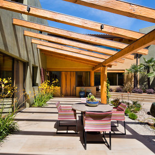 Immagine di un grande patio o portico stile americano dietro casa con fontane, una pergola e piastrelle