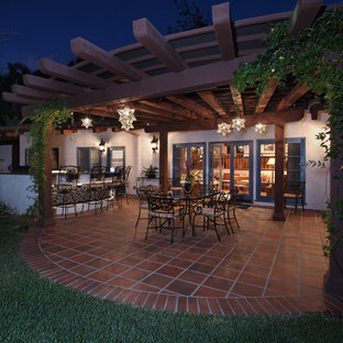 Ispirazione per un grande patio o portico mediterraneo dietro casa con piastrelle e una pergola