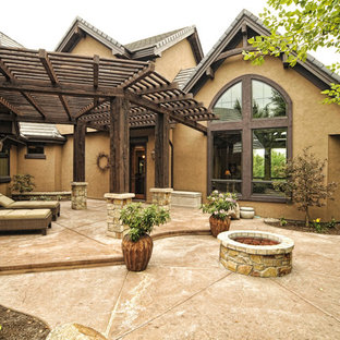 Photo of a large classic back patio in Boise with a fire feature, stamped concrete and a pergola.
