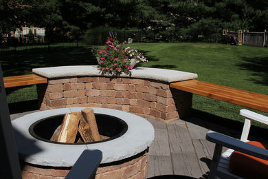 Patio - mid-sized industrial backyard concrete paver patio idea in Kansas City with a fire pit and a roof extension