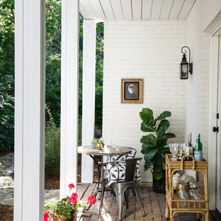 Foto di un patio o portico classico con un giardino in vaso, pavimentazioni in mattoni e un tetto a sbalzo