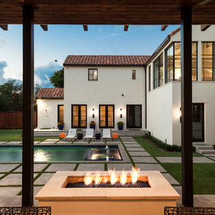 Immagine di un ampio patio o portico mediterraneo dietro casa con un focolare e pavimentazioni in cemento