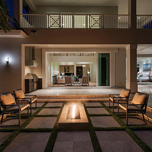 Idee per un patio o portico tropicale con un focolare e nessuna copertura