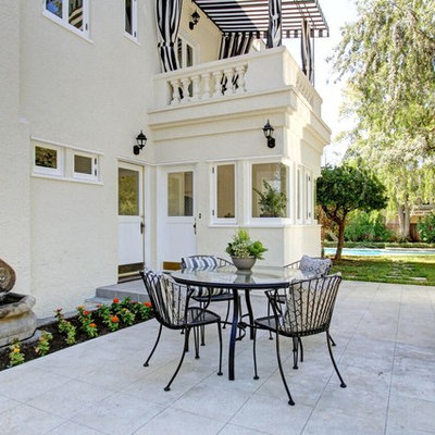Example of a classic backyard concrete paver patio fountain design in Los Angeles with no cover