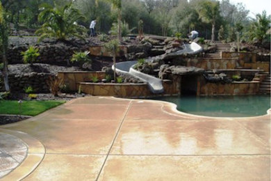 Photo of a large world-inspired back patio in Sacramento with a water feature, concrete slabs and no cover.