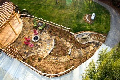 Modelo de patio grande en patio lateral con brasero, adoquines de piedra natural y pérgola