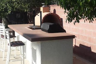 ロサンゼルスにある中くらいなトラディショナルスタイルのおしゃれな裏庭のテラス (アウトドアキッチン、コンクリート板舗装	、日よけなし) の写真