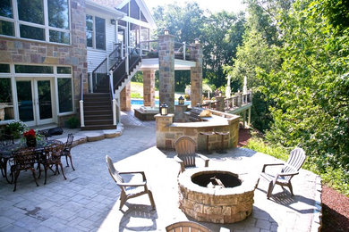 Exemple d'une grande terrasse arrière craftsman avec une cuisine d'été et des pavés en pierre naturelle.