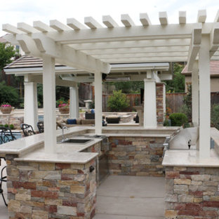 Idee per un grande patio o portico american style dietro casa con pavimentazioni in cemento e una pergola