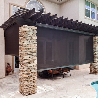 Idee per un patio o portico tradizionale di medie dimensioni e dietro casa con pavimentazioni in pietra naturale e un parasole