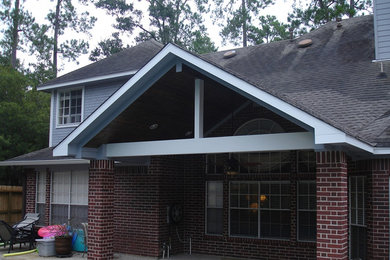 Large classic back patio in Houston with an outdoor kitchen, stamped concrete and a roof extension.