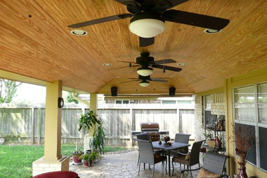 Inspiration pour une terrasse arrière chalet de taille moyenne avec du béton estampé et une extension de toiture.