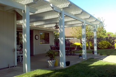 Imagen de patio contemporáneo de tamaño medio en patio trasero con pérgola