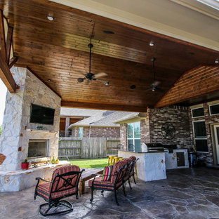 Cette image montre une terrasse arrière traditionnelle avec du béton estampé et une extension de toiture.