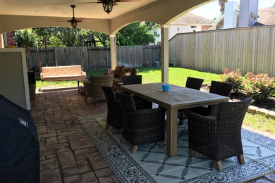 Patio - large traditional backyard patio idea in Houston with a roof extension