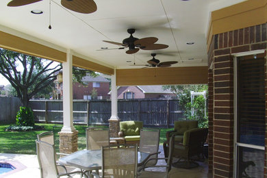 Mid-sized backyard stamped concrete patio photo in Houston with a roof extension
