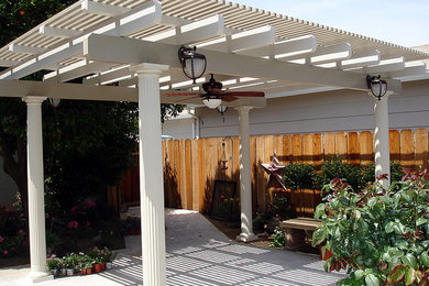 Foto de patio clásico de tamaño medio en patio trasero con suelo de hormigón estampado y toldo