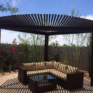 Immagine di un piccolo patio o portico stile americano dietro casa con pavimentazioni in pietra naturale e una pergola