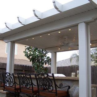 Example of a small classic backyard concrete patio kitchen design in Other with a gazebo