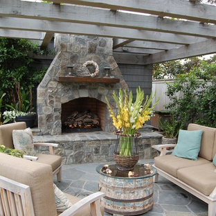 Idee per un patio o portico stile marinaro con un focolare e una pergola