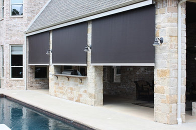 Example of a mid-sized classic backyard stone patio kitchen design in Dallas with a roof extension