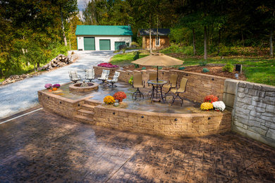 Patio - large contemporary side yard stone patio idea in Cincinnati with a fire pit and no cover