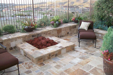Example of a tuscan backyard stone patio design in Orange County