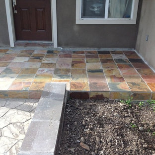 Immagine di un patio o portico costiero di medie dimensioni e davanti casa con pavimentazioni in pietra naturale e nessuna copertura