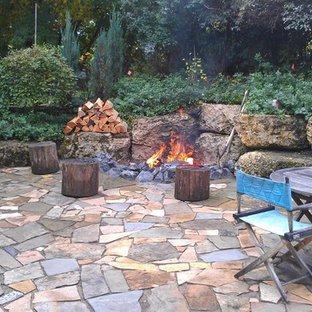 Immagine di un patio o portico stile rurale di medie dimensioni e dietro casa con un focolare, pavimentazioni in cemento e nessuna copertura