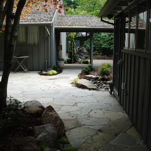 Ispirazione per un grande patio o portico etnico dietro casa con pavimentazioni in pietra naturale e un tetto a sbalzo