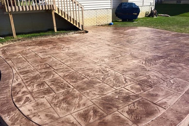 This is an example of a small traditional back patio in Cincinnati with stamped concrete and no cover.