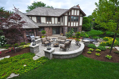Large elegant backyard brick patio photo in Chicago with a fire pit and no cover