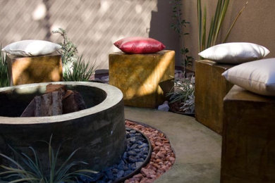 Diseño de patio contemporáneo de tamaño medio sin cubierta en patio trasero con fuente y suelo de hormigón estampado